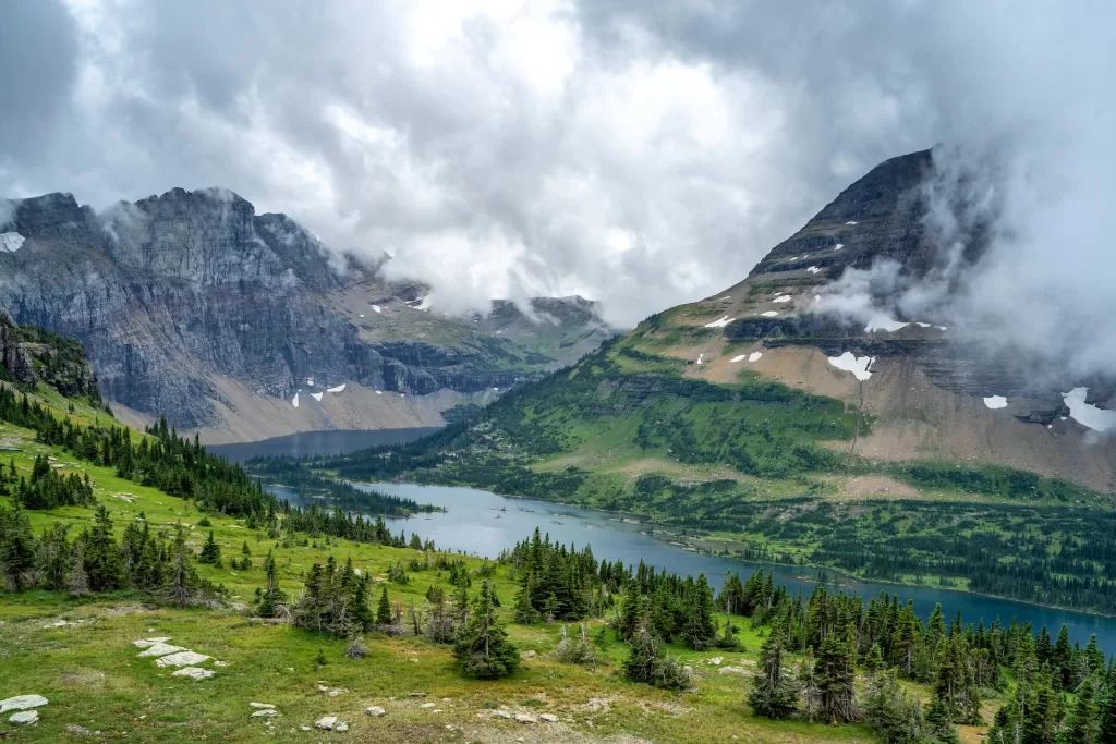 A hiker stands at the viewpoint overlooking Hidden Lake in Glacier National Park