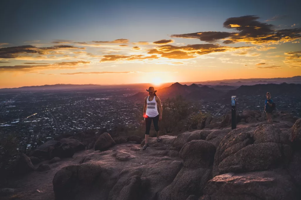 hikers enjoying the scenic vista from the top of Piestewa Peak, a popular hike in Phoenix.