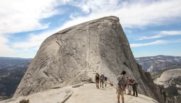 Hiking Half Dome The line up the center is a ~400 ft ascent to the summit at a 45º angle, aided by two thick braided cable railings. An average of 2 people a year die on this part of the hike.